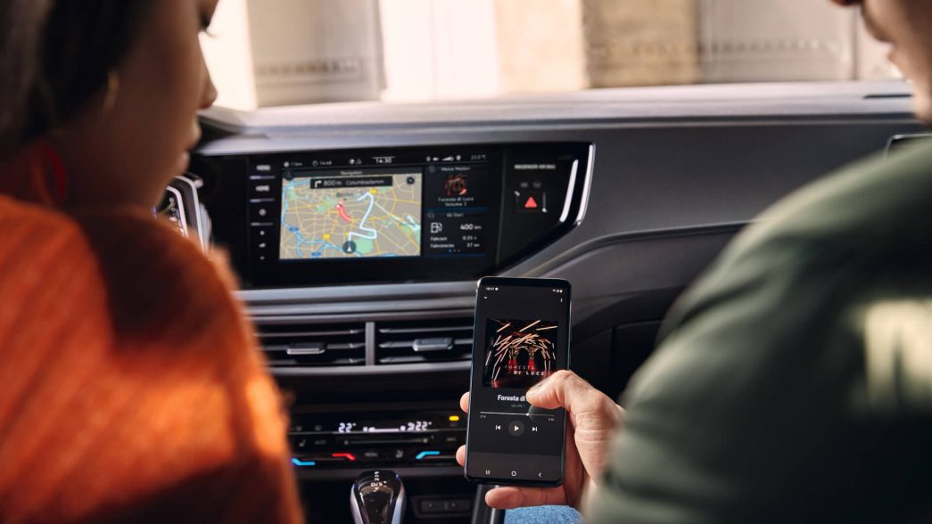 Im VW Polo zeigt Beifahrer der Fahrerin Smartphone 