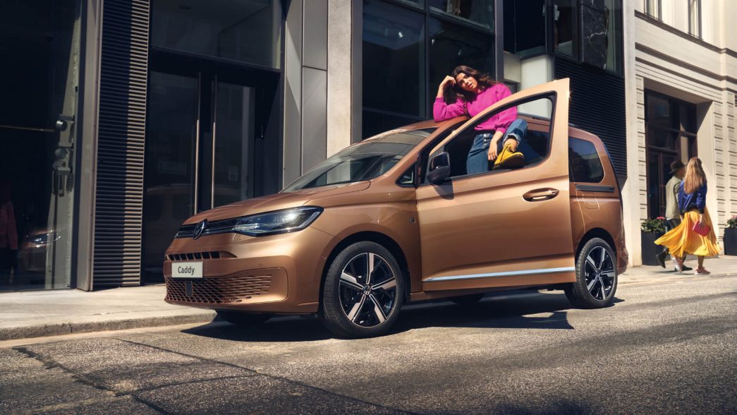 VW Caddy vue de face et latérale avec porte ouverte et une femme