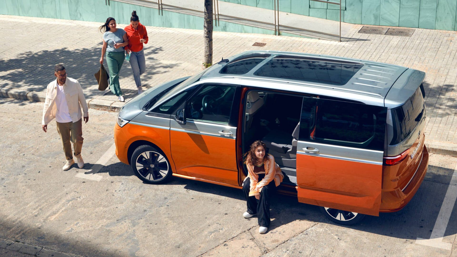 VW Multivan orange et gris sur un parking