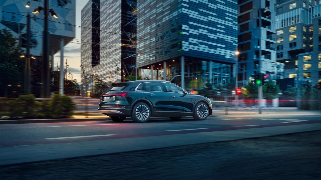 Blue Audi e-tron on a city street side view