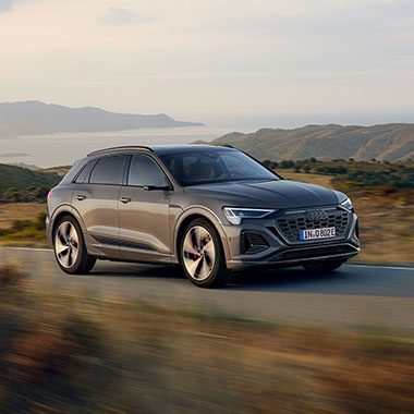 Grey Audi Q8 e-tron side and front view on a country road
