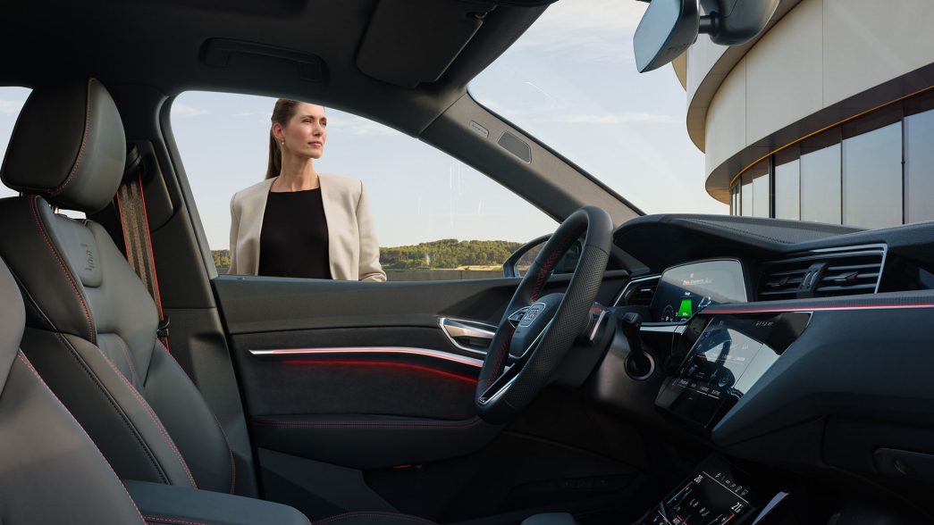 Audi Q8 e-tron cockpit side view with woman next to the car