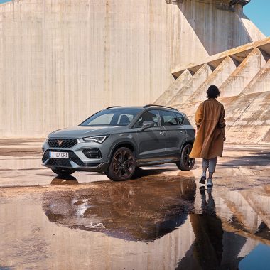 CUPRA Ateca avec femme à côté devant un mur en béton