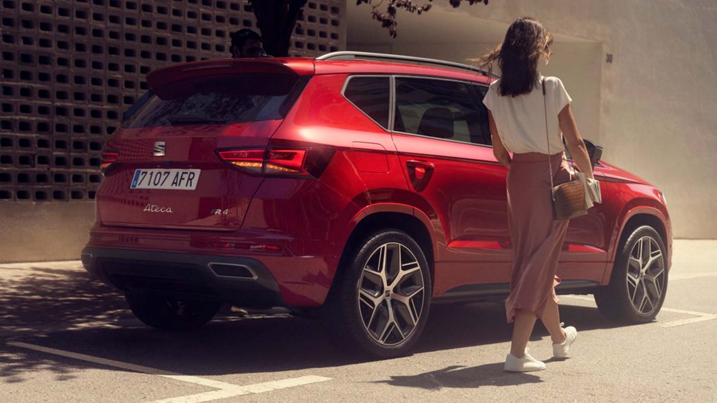 SEAT Ateca rouge vue latérale et arrière avec femme à côté