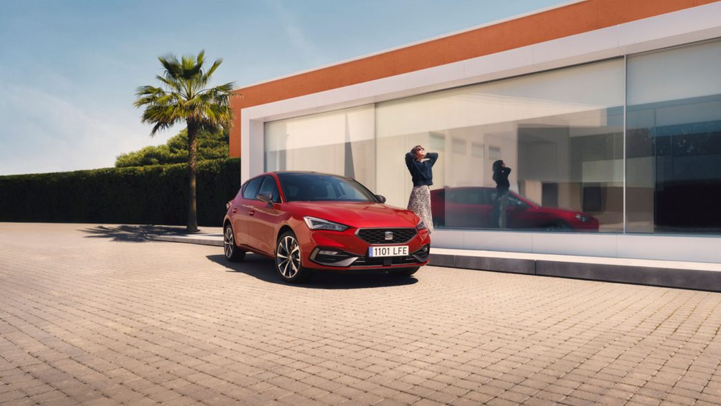 SEAT Leon rouge vue de face et latérale devant maison