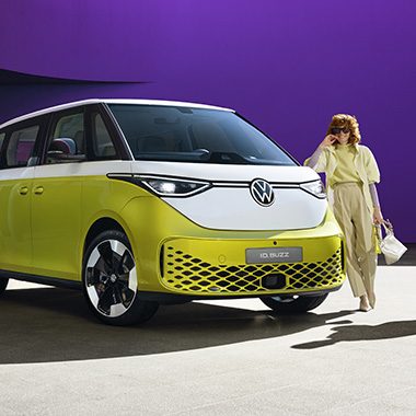 AMAG l'ID VW. Buzz in bianco giallo, fronte laterale con donna davanti.