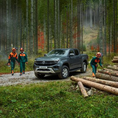 Un Amarok con operai forestali nella foresta.