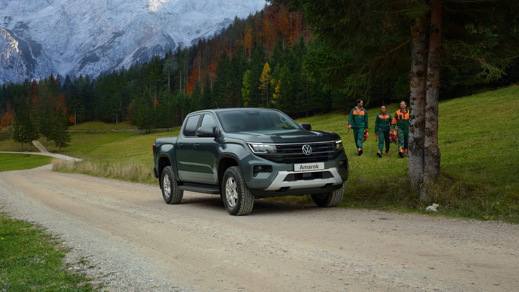 Un Amarok sur un chemin forestier avec des forestiers en arrière-plan.