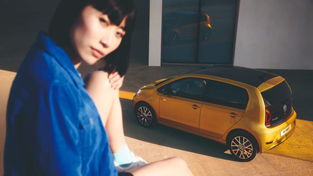 VW e-up ! jaune vue latérale d'en haut avec femme