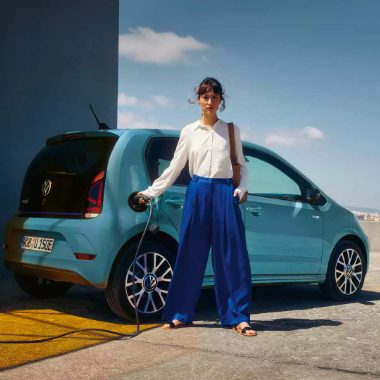 Chargement d'une VW e-up! bleue avec une femme devant