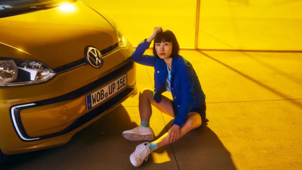 Yellow VW e-up! Front with woman