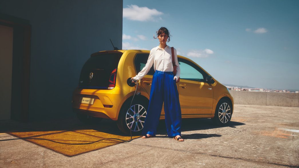 Chargement d'une VW e-up ! jaune vue latérale avec femme devant