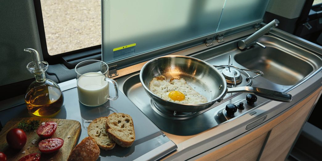 Kitchen in the VW California with egg, bread, tomato, milk and oil