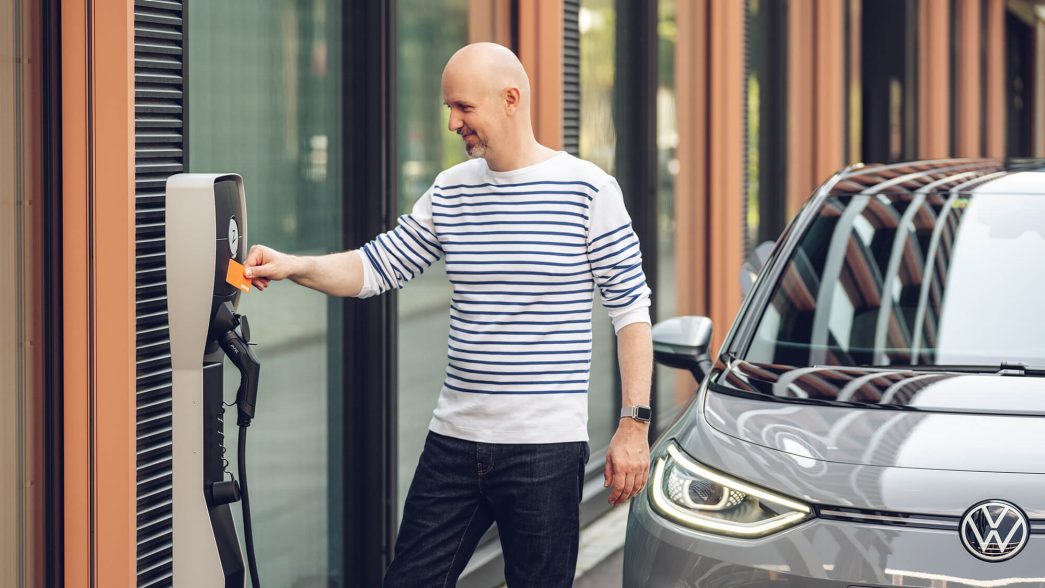 Un homme active la borne de recharge avec une carte