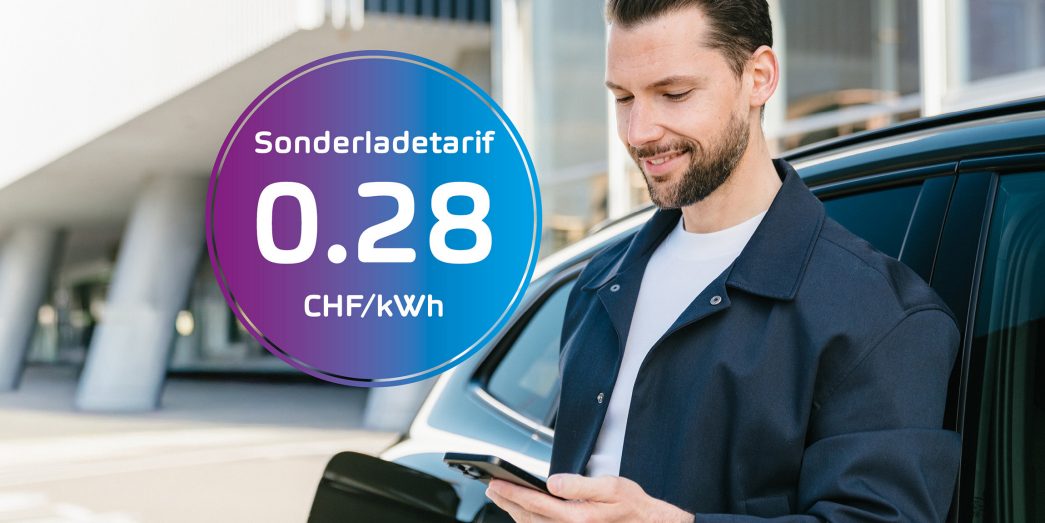 Mann lehnt an der Seite eines Fahrzeugs mit einem Handy in der Hand, im Hintergrund eine AMAG Garage